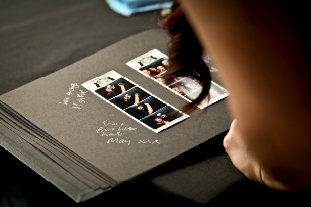 A black photo album with two photo strips on it